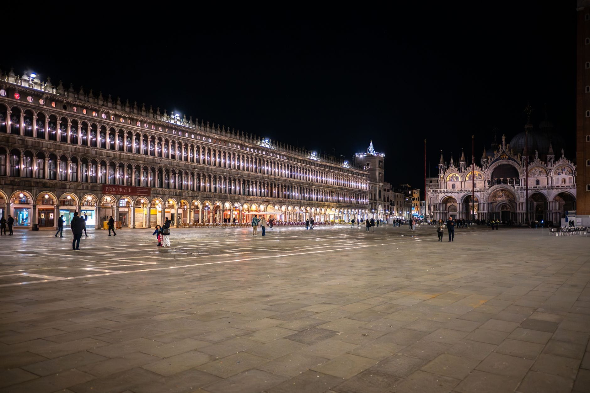 Piazza San Marco at blue hour, the arcades lit gold under a deep blue sky