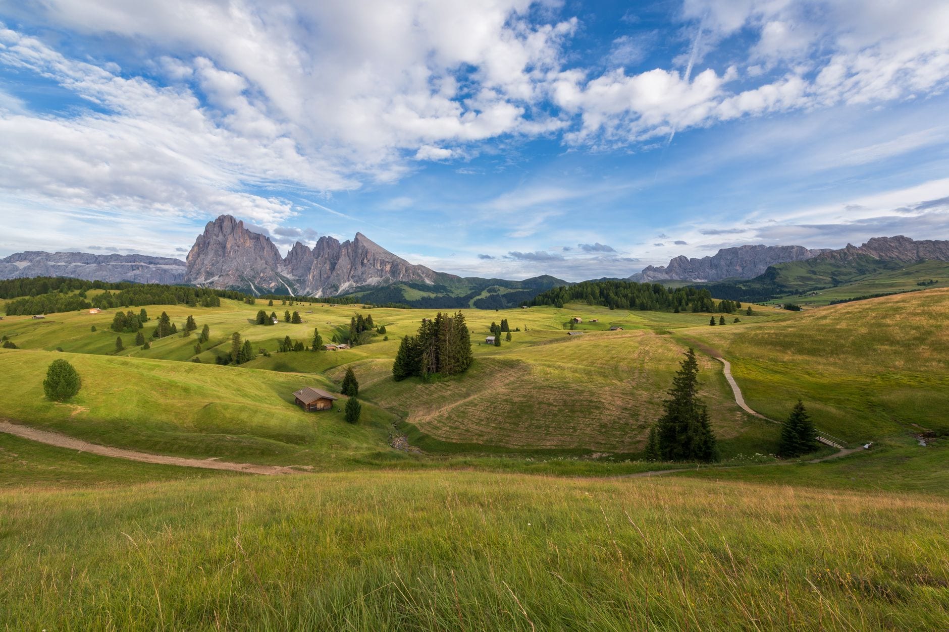 Rolling meadows and winding paths beneath the Sassolungo massif