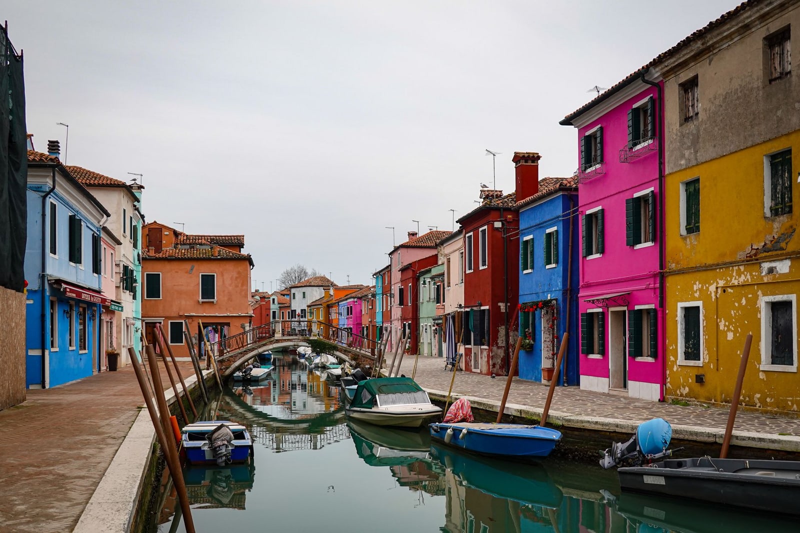 Colourful canal-side houses and moored boats in Burano