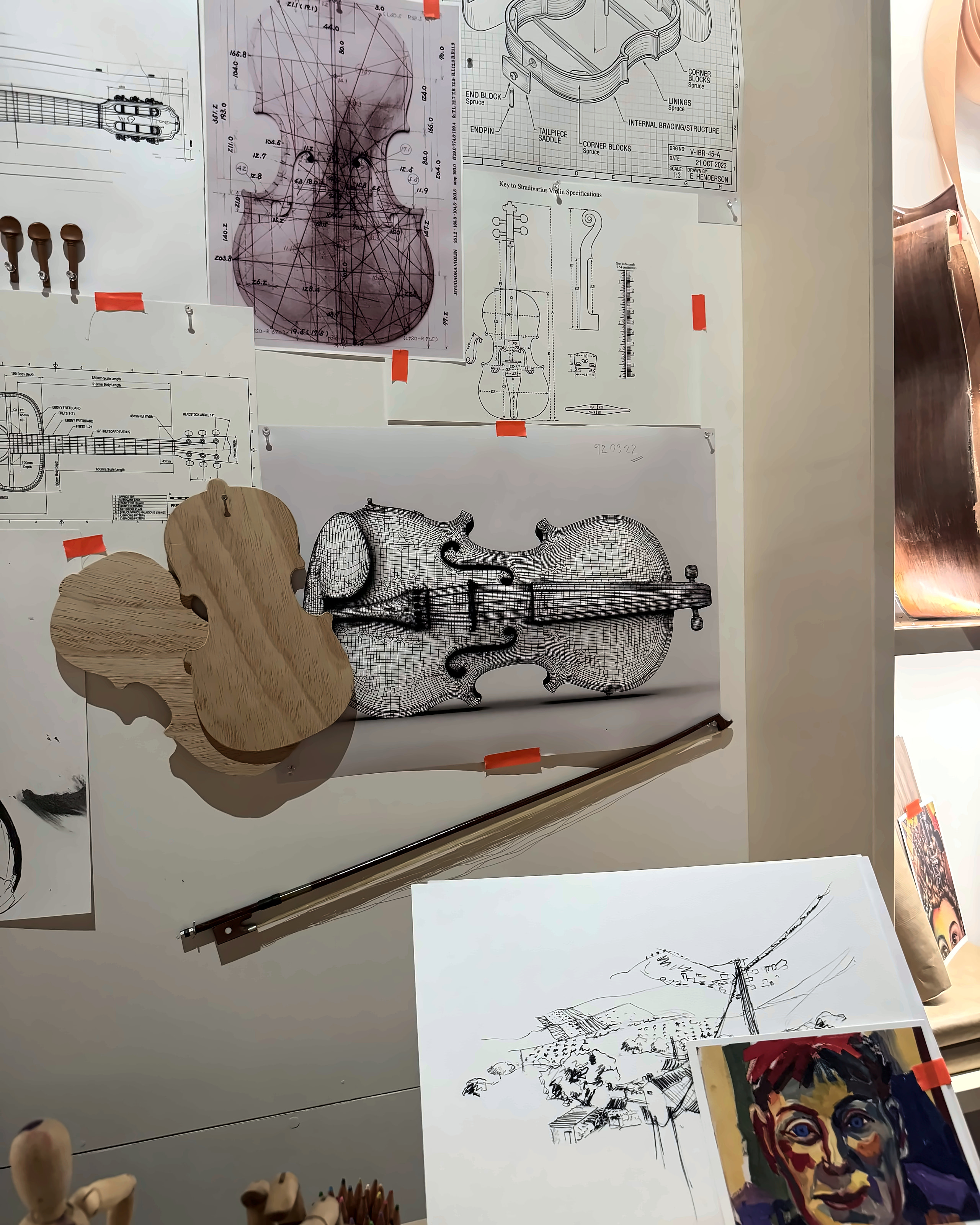 Violin drawings and carved scrolls on a luthier's wall